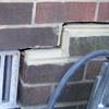 A closeup of a failed tuckpointing job where the brick cracked on a Globe home.